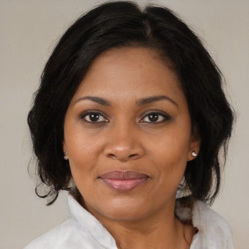Joyful black adult female with medium  brown hair and brown eyes