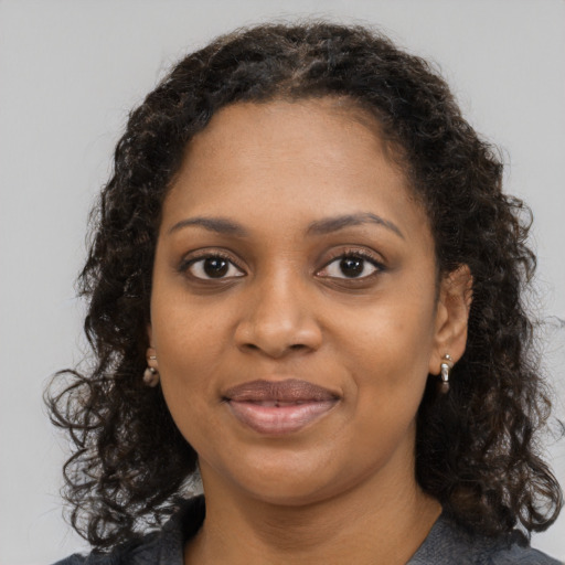 Joyful black young-adult female with medium  brown hair and brown eyes
