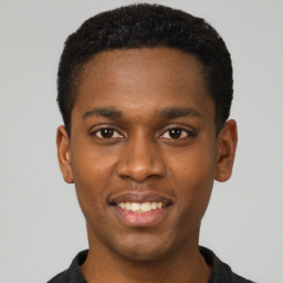 Joyful black young-adult male with short  black hair and brown eyes