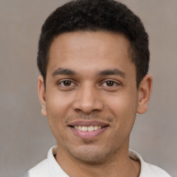 Joyful latino young-adult male with short  brown hair and brown eyes