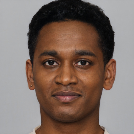 Joyful black young-adult male with short  black hair and brown eyes