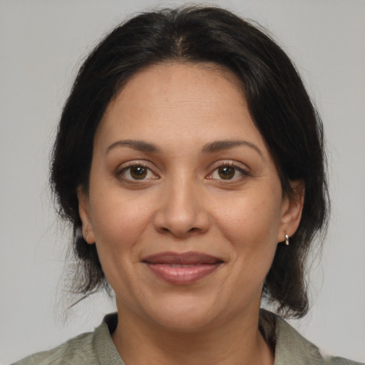 Joyful latino adult female with medium  brown hair and brown eyes