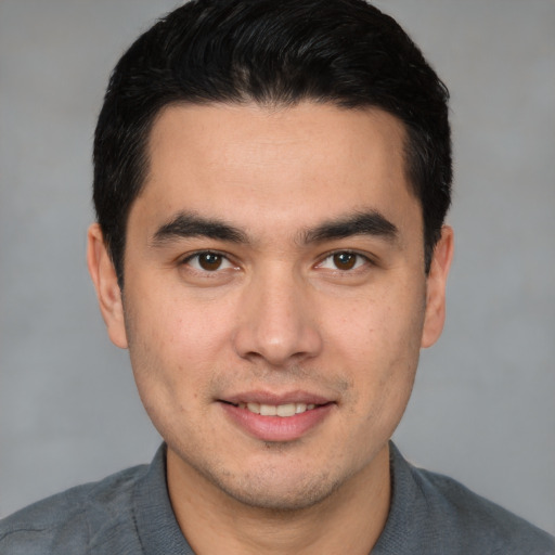 Joyful white young-adult male with short  black hair and brown eyes