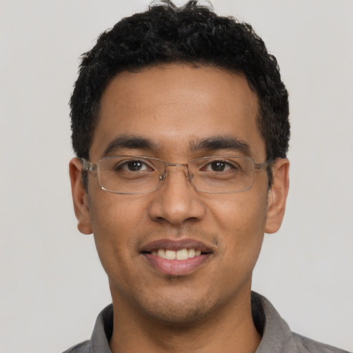 Joyful latino young-adult male with short  black hair and brown eyes