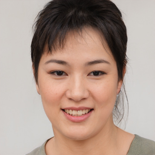 Joyful asian young-adult female with medium  brown hair and brown eyes