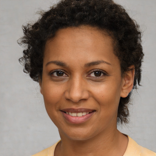 Joyful black young-adult female with short  brown hair and brown eyes