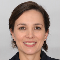 Joyful white young-adult female with medium  brown hair and brown eyes