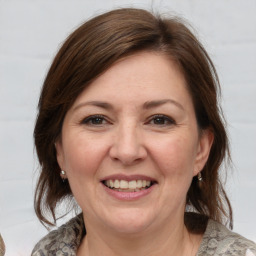 Joyful white adult female with medium  brown hair and grey eyes