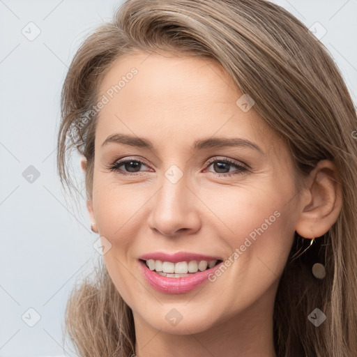 Joyful white young-adult female with long  brown hair and brown eyes