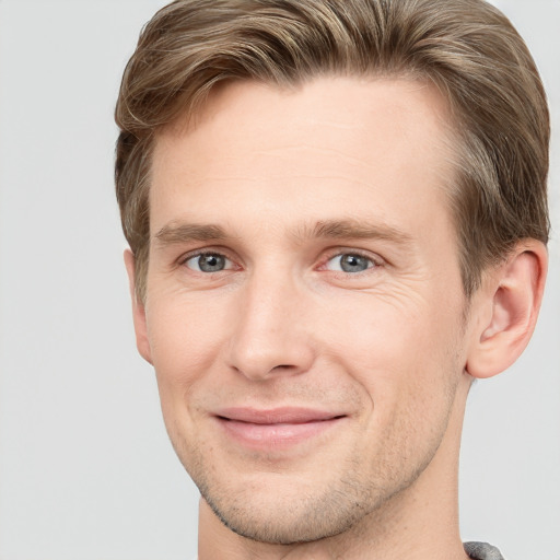 Joyful white young-adult male with short  brown hair and grey eyes