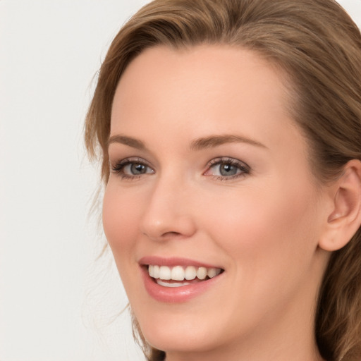 Joyful white young-adult female with long  brown hair and blue eyes