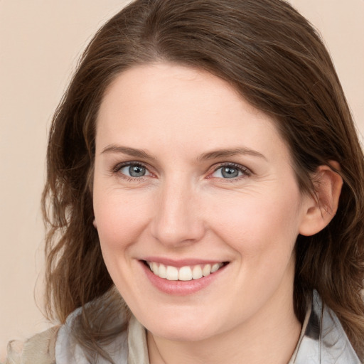 Joyful white young-adult female with medium  brown hair and blue eyes