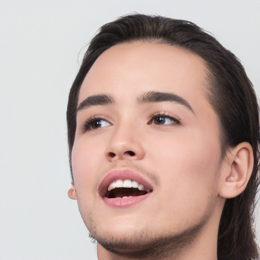 Joyful white young-adult male with long  black hair and brown eyes