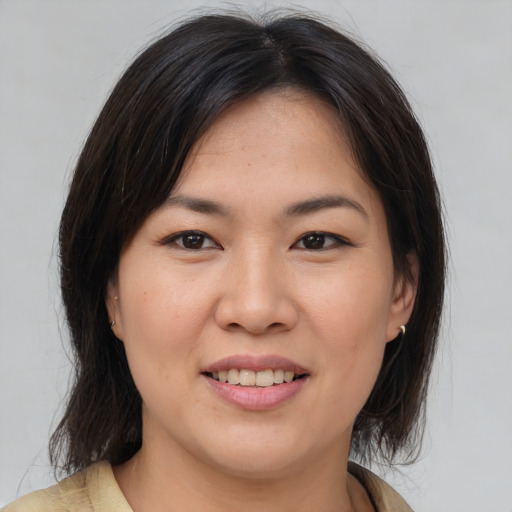 Joyful asian young-adult female with medium  brown hair and brown eyes