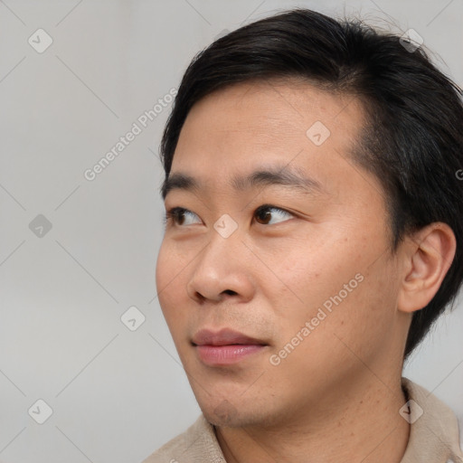 Joyful asian young-adult male with short  brown hair and brown eyes