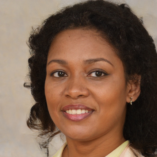 Joyful black young-adult female with medium  brown hair and brown eyes