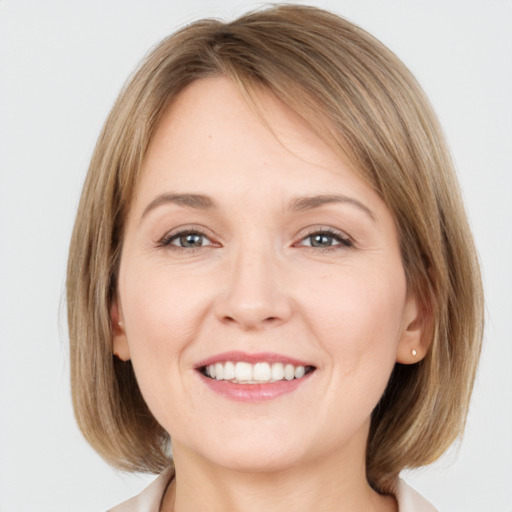 Joyful white young-adult female with medium  brown hair and grey eyes