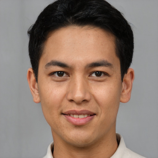 Joyful latino young-adult male with short  brown hair and brown eyes