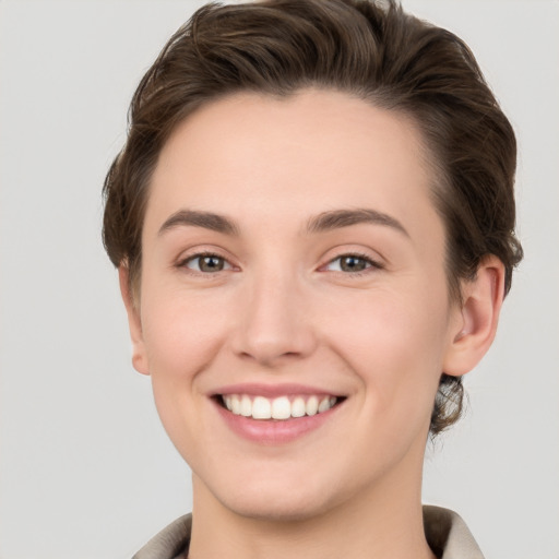 Joyful white young-adult female with short  brown hair and grey eyes