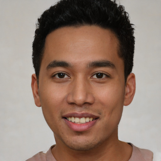 Joyful latino young-adult male with short  black hair and brown eyes