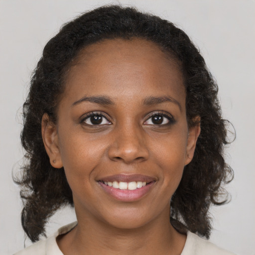 Joyful black young-adult female with medium  brown hair and brown eyes