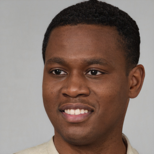 Joyful black young-adult male with short  brown hair and brown eyes