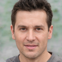 Joyful white adult male with short  brown hair and grey eyes