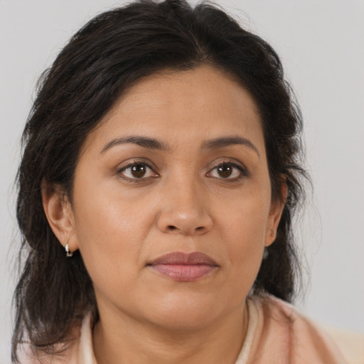 Joyful latino adult female with medium  brown hair and brown eyes