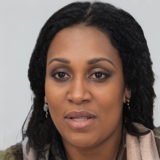 Joyful black young-adult female with long  black hair and brown eyes