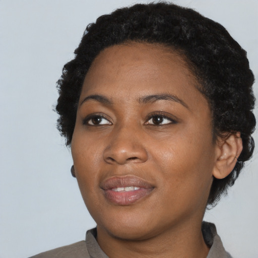 Joyful black adult female with short  black hair and brown eyes