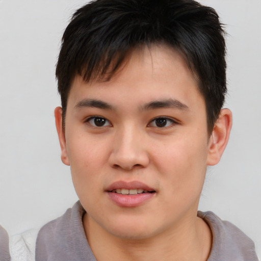 Joyful asian young-adult male with short  brown hair and brown eyes