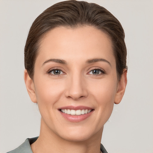 Joyful white young-adult female with short  brown hair and grey eyes