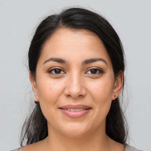 Joyful latino young-adult female with medium  brown hair and brown eyes