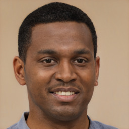 Joyful black young-adult male with short  brown hair and brown eyes