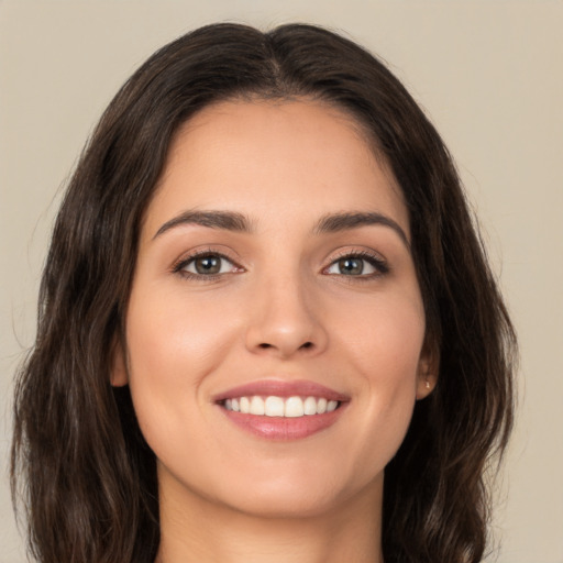 Joyful white young-adult female with long  brown hair and brown eyes