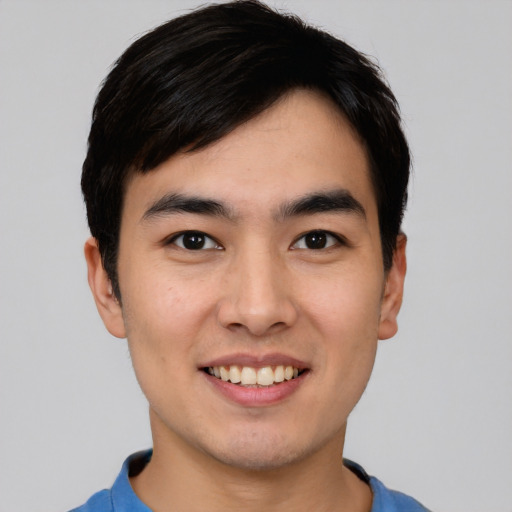 Joyful asian young-adult male with short  black hair and brown eyes