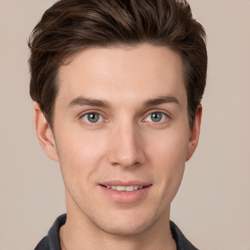 Joyful white young-adult male with short  brown hair and grey eyes