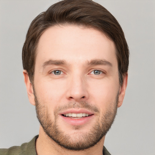 Joyful white young-adult male with short  brown hair and grey eyes