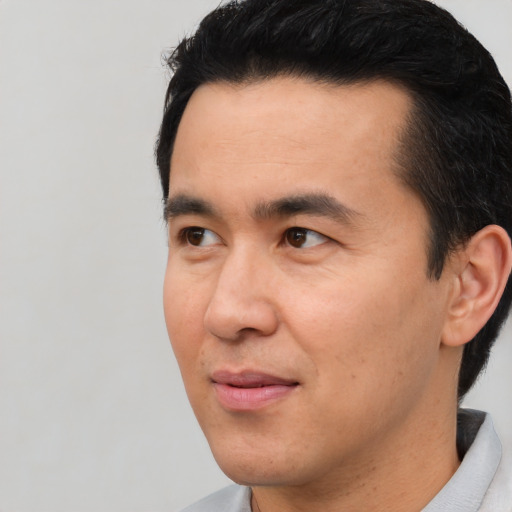 Joyful asian young-adult male with short  black hair and brown eyes