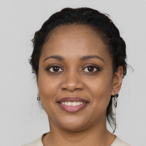 Joyful black young-adult female with long  black hair and brown eyes