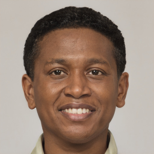 Joyful black young-adult male with short  brown hair and brown eyes