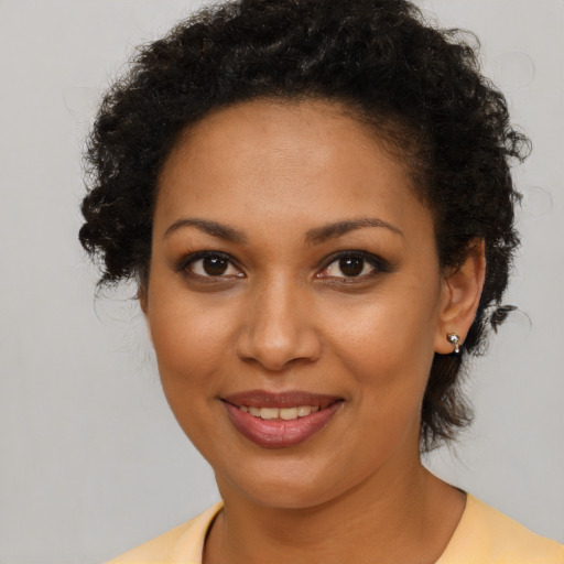 Joyful black young-adult female with short  brown hair and brown eyes