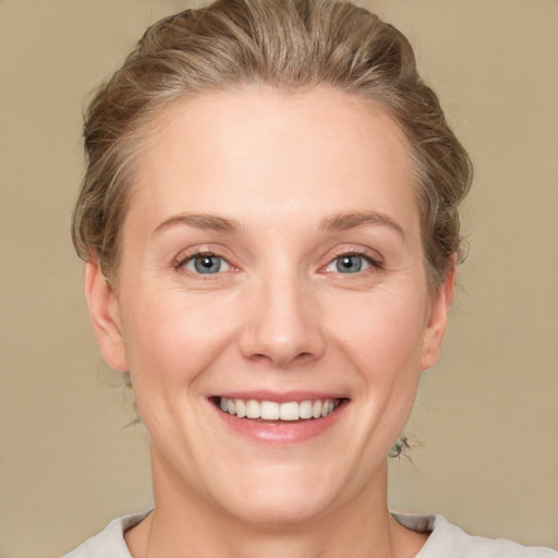 Joyful white adult female with medium  brown hair and blue eyes