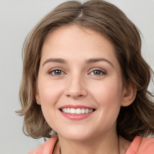 Joyful white young-adult female with medium  brown hair and green eyes