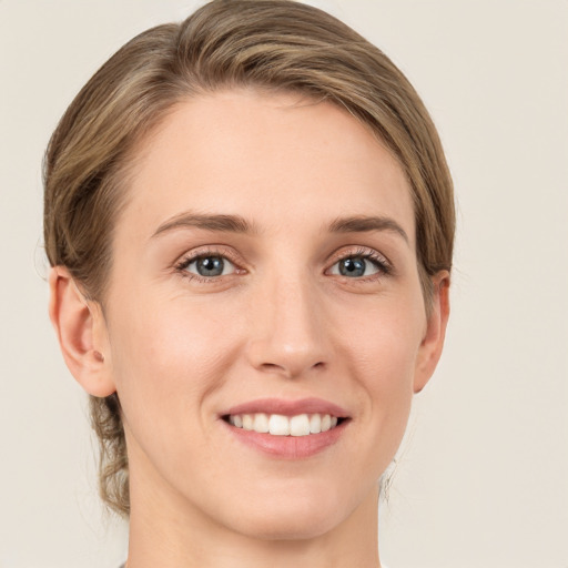 Joyful white young-adult female with medium  brown hair and green eyes