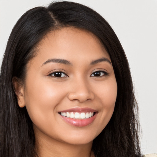 Joyful latino young-adult female with long  brown hair and brown eyes