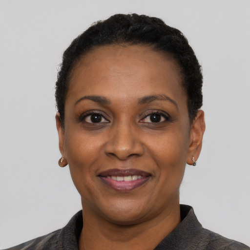 Joyful black adult female with short  black hair and brown eyes