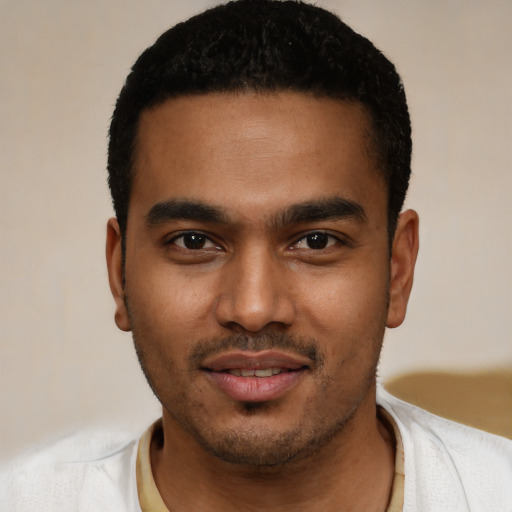 Joyful black young-adult male with short  black hair and brown eyes