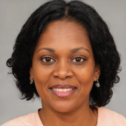 Joyful black adult female with medium  brown hair and brown eyes