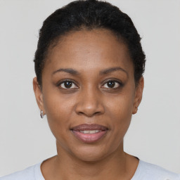 Joyful black young-adult female with short  brown hair and brown eyes